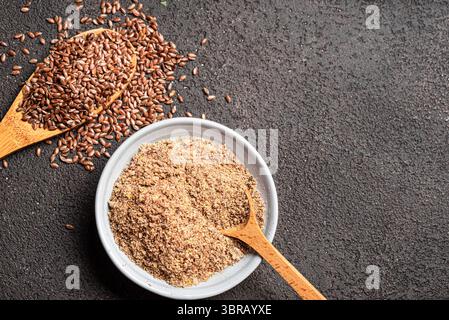 Leinsamen auf Holzlöffel und Flachssamen gemahlen, Draufsicht, Kopierraum. Gesunde Ernährung. Ökologisches Produkt. Stockfoto
