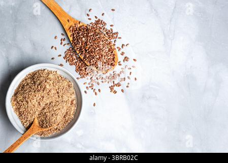 Flaxseeds ganz und gemahlen von Flachssamen auf Marmorhintergrund, Blick von oben. Gesunde Lebensmittelzutat, Superfood. Ökologisches Produkt. Stockfoto
