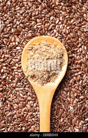 Flaxseeds als Hintergrund und gemahlen von Flachssamen auf Holzlöffel, Blick von oben. Gesunde Lebensmittelzutat, Superfood. Ökologisches Produkt. Stockfoto