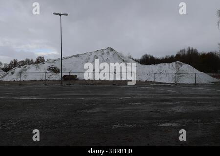 Schneebedeckter Hügel mit einem Zaun im Hintergrund Stockfoto
