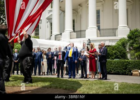 Präsident Donald J. Trump würdigt, als eine neue amerikanische Flagge auf dem South Lawn während einer patriotischen Zeremonie im Weißen Haus schwingt. Washington, D.C. 18. Juni 2024. Bild mit freundlicher Genehmigung des Weißen Hauses. Stockfoto