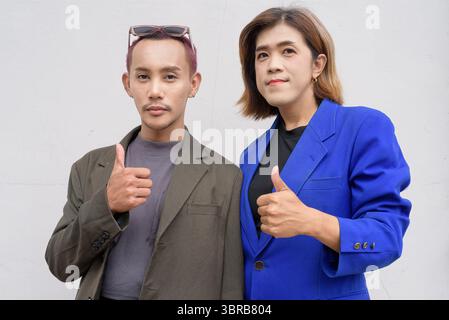 Geschlechtsinklusives asiatisches Business-Team-Paar vor weißem Hintergrund Stockfoto