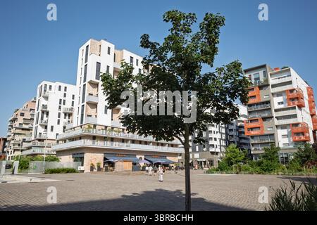 Ein beeindruckendes modernes Wohngebäude in Saint-Ouen, Frankreich, mit einzigartigen Balkonen mit orangefarbenen Akzenten und modernem Design. Stockfoto