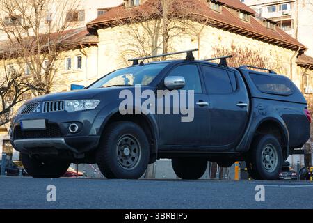 Bukarest, Rumänien – 6. Januar 2025: Nahaufnahme des schwarzen Autos des Mitsubishi L200 Pickup-Trucks auf dem Parkplatz in der Stadt Stockfoto