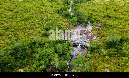 Aus der Vogelperspektive eines ruhigen Baches, der durch dichtes Grün in Guaviare, Kolumbien, fließt und die natürliche Schönheit der Region zeigt. Stockfoto