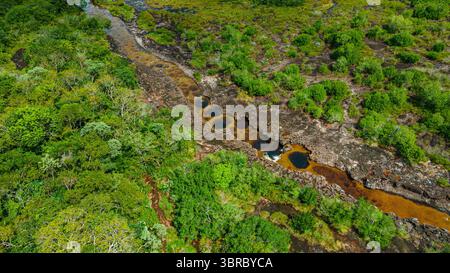Atemberaubende Perspektive auf eine lebendige grüne Landschaft mit gewundenen Flüssen und natürlichen Felsformationen in Guaviare, Kolumbien. Stockfoto