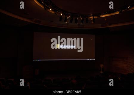 Tainan, Taiwan – 29. Juni 2025: Dunkles Auditorium im National Museum of Taiwan History mit einer beleuchteten Projektionsleinwand mit dem m Stockfoto