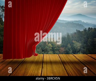 Der rote Samtvorhang enthüllt nebelige Wälder und Bergtäler auf einer Holzbühne in flachem Design Stockfoto