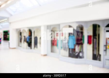 In der Reihe mit bogenförmigen Glasfassaden werden Kleiderständer und Schaufensterpuppen in flachem Design präsentiert Stockfoto