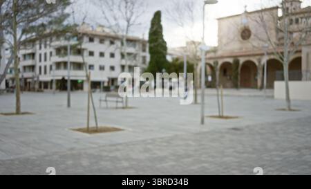 Verschwommene Straßenszene in einer mediterranen Altstadt mit defokussierter Architektur und leerem urbanem plaza unter bewölktem Himmel mit Bokeh-Effekt. Stockfoto