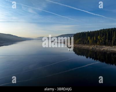 Luftaufnahme des ruhigen, dunklen Wassers, das den ruhigen Himmel und die dichte, dunkelgrüne Waldlinie reflektiert, Schluchsee, Baden-Württemberg, Deutschland. Stockfoto
