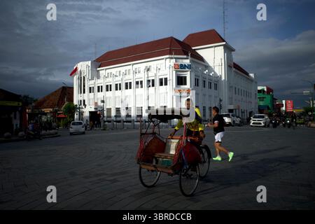 Yogyakarta, Indonesien - 26. Dezember 2024: Becak oder ein Pedicab und ein Läufer im Zentrum von Yogyakarta City, Indonesien, in der Nähe der Malioboro Street Stockfoto