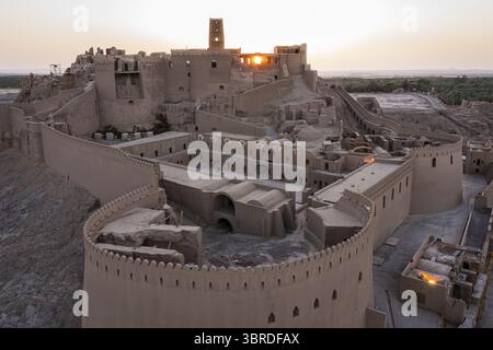 Aus der Vogelperspektive der alten Zitadelle Arg-e BAM leuchtet im warmen Licht auf der Wüstenlandschaft, ein Zeugnis der Geschichte und Widerstandsfähigkeit, BAM, Provinz Kerman, Iran. Stockfoto