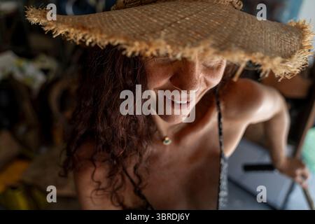 Lächelndes Porträt einer Frau mittleren Alters mit rotem Haar mit Strohhut Stockfoto