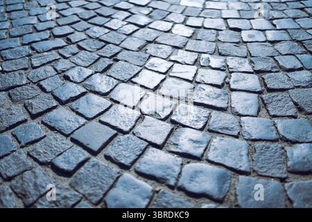 Close-up-Textur aus geschwungenem Stein Pflastersteinpflaster in Blauton Stockfoto
