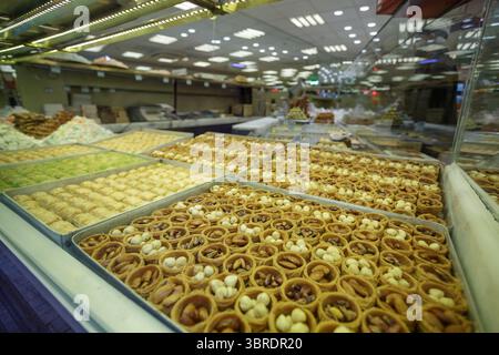 Nahaufnahme verschiedener türkischer Süßigkeiten und Gebäck mit Nüssen und Honig in einer Bäckerei, traditionelle orientalische Desserts Stockfoto