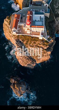 Aus der Vogelperspektive auf den zerklüfteten Klippen, geküsst vom goldenen Licht der untergehenden Sonne, Sagres, Faro, Portugal. Stockfoto