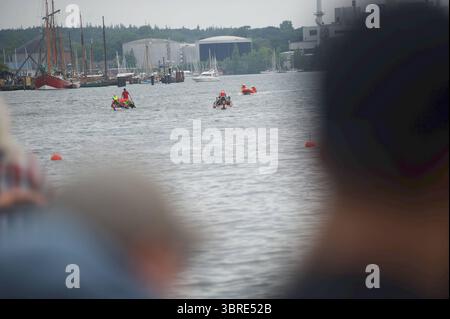 Flensburg, Schleswig-Holstein Flensburger Drachenbootrennen. Ein Drachenboot mit pink gekleideten Ruderern und Schwimmwesten fährt auf dem Wasser. Am Bug ist ein Drachenkopf zu sehen, das Boot trägt eine Startnummer. Im Hintergrund sind Begleitboote, orangefarbene Bojen und Gebäude am Ufer zu erkennen. Aufnahme vom 12.07.2025, Flensburg, Hafen West, Hafenspitze *** Flensburg, Schleswig Holstein Drachenboot-Rennen Ein Drachenboot mit rosa Rudern und Schwimmwesten segelt auf dem Wasser Ein Drachenkopf ist am Bug Zu sehen, das Boot trägt eine Startnummer im Hintergrund Stockfoto