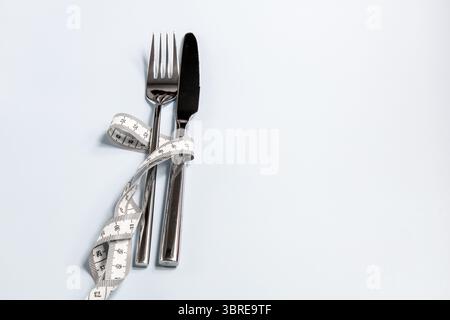 Gabel und Messer in ein Maßband gewickelt. Hochwertige Fotos Stockfoto