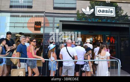 Manchester, Großbritannien, 12. Juli 2025 eifrige Oasis-Fans stehen in einem Geschäft in der Market Street, im Zentrum von Manchester, Großbritannien, für Oasis-Waren an. Die Stadt bereitet sich auf das zweite Oasis-Konzert am Samstag vor, an dem rund 70.000 Fans teilnehmen. Liam und Noel Gallagher geben insgesamt fünf Konzerte im Rahmen ihrer Oasis Live '25 Tour. Quelle: Terry Waller/Alamy Live News Stockfoto