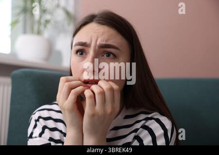Besorgte Frau, die zu Hause an Paranoia leidet Stockfoto