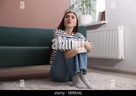 Frau mit Paranoia auf dem Boden zu Hause Stockfoto