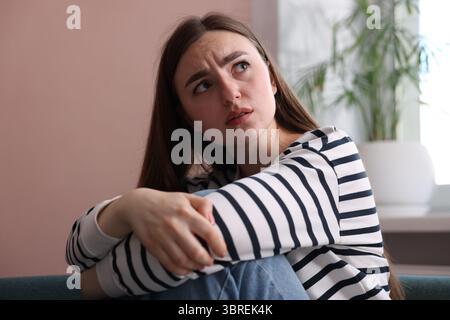 Verängstigte Frau, die zu Hause an Paranoia leidet Stockfoto