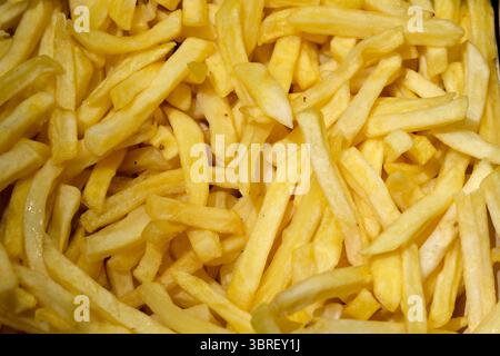 Goldene Pommes Frites stapeln sich hoch und fangen die Essenz des Wohlgefühls ein. Stockfoto