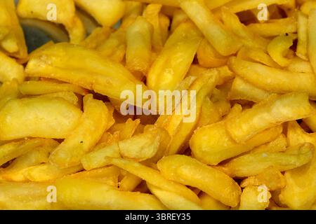 Knusprige gebratene Snacks stapelten sich hoch, verlockend auf einem geschäftigen Markt Passanten. Stockfoto