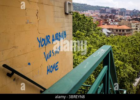 „Your Airbnb Was My Home“ Graffiti, das auf eine Wand in Bilbao im Baskenland im Norden Spaniens gesprüht wurde. Stockfoto