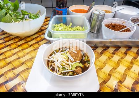 Traditionelle thailändische Nudelsuppe mit gedünstetem Huhn, serviert im Food Court FoodPark in BigC plaza, Bangkok, Thailand Stockfoto
