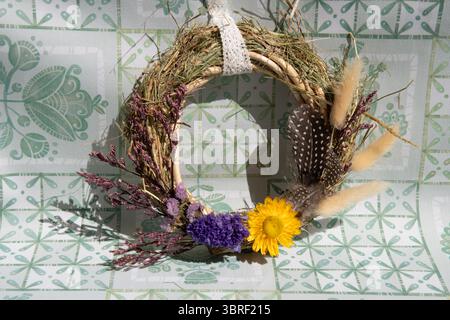 Der zarte Kranz zeigt eine Reihe von getrockneten Blumen, Kräutern und Gräsern, die die natürliche Schönheit zeigen. Stockfoto