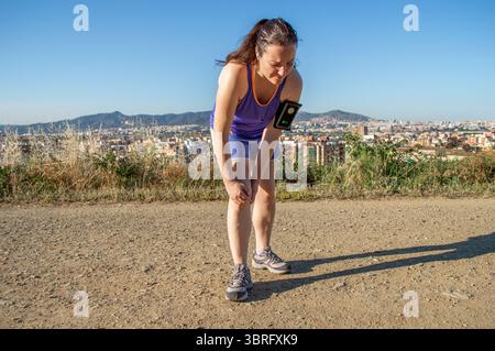 Denken Sie immer daran, sich zu strecken. Eine sportliche junge Frau, die an einer Sportverletzung leidet. Stockfoto
