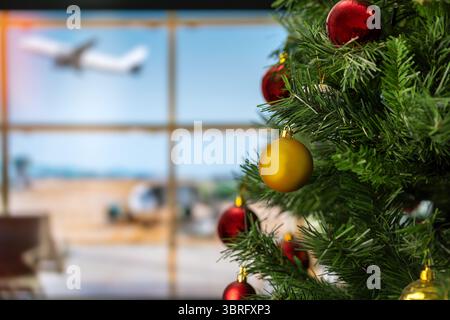 Ein nicht erkennbarer Flughafenstandort mit einem geschmückten Weihnachtsbaum im Vordergrund Stockfoto