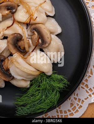 Traditionelle Knödel mit Pilzen und Kräutern auf Teller Stockfoto