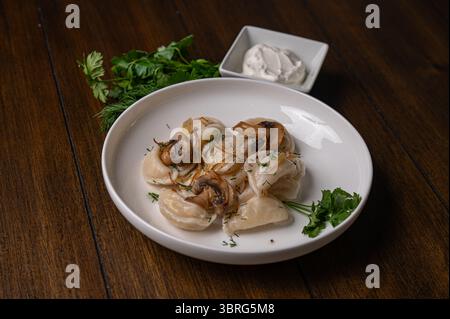 Traditionelle Knödel mit Pilzen und Kräutern auf Teller Stockfoto