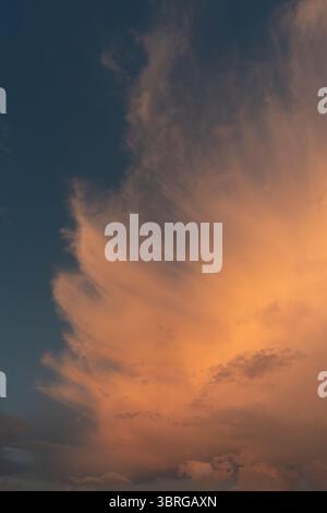 Ein wunderschönes Bild von Wolken, gefiederten Wolken im Licht der untergehenden Sonne, flauschigen Wolken am blauen Himmel Stockfoto