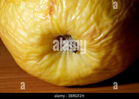 Nahaufnahme einer leuchtenden gelben Frucht, die auf einem Holztisch liegt. Stockfoto