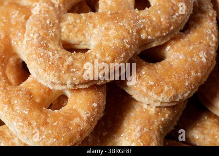 Köstliche goldene Brezeln mit Zuckerglasur verführen Passanten, frisch zubereitet. Stockfoto
