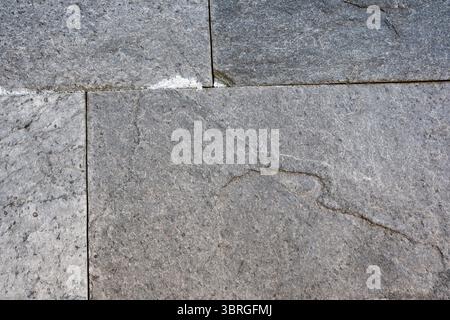Verwitterte graue Steine vermischen sich in einem harmonischen Muster unter Sonnenlicht. Stockfoto