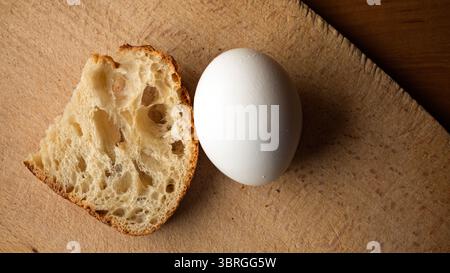 Einfache Zutaten wie Brot und ein Ei unterstreichen die Freude am Morgen des Essens. Stockfoto