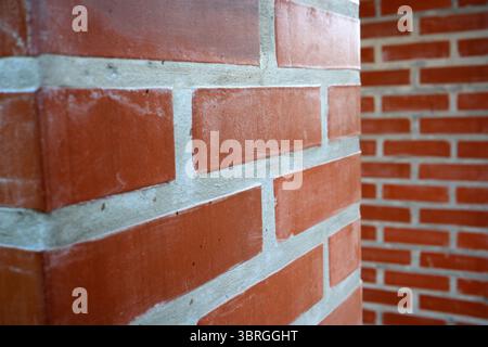 Aus nächster Nähe sehen Sie rustikale rote Ziegelsteine, die ihre einzigartigen Texturen und Farben zeigen. Stockfoto