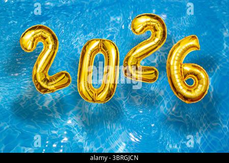 2026 aufblasbare goldene Zahlen auf dem Wasser kräuseln die Oberfläche, ein glückliches neues Jahr mit einer Pool-Party Stockfoto