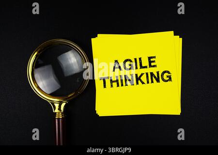 Agiles Denken auf Haftnotiz mit Vergrößerungsglas auf schwarzem Hintergrund Stockfoto