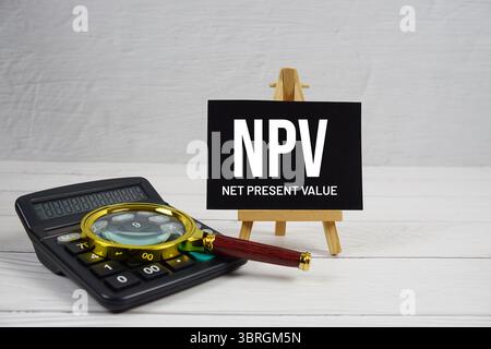 NPV abbreviation of Net Present Value text with magnifying glass and calculator on wooden background Stockfoto