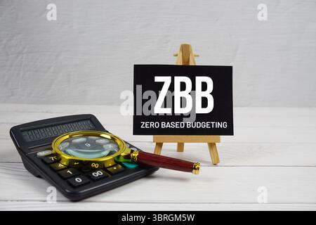 ZBB-Abkürzung für Zero Based Budgeting Text mit Lupe und Rechner auf hölzernem Hintergrund Stockfoto