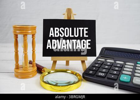 Absoluter Advantage-Text mit Lupe und Rechner auf hölzernem Hintergrund Stockfoto