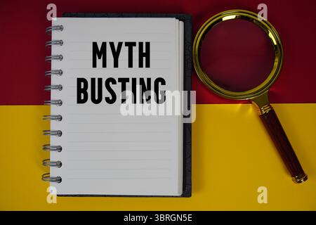 Mythensprenger Text auf Notizbuch mit Lupe geschrieben Stockfoto