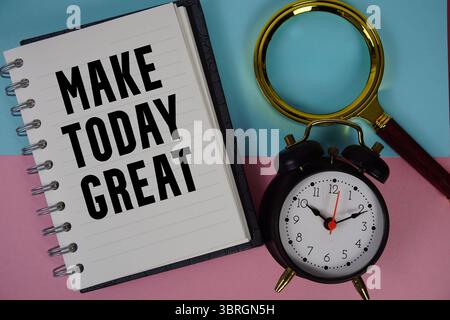 Make Today großartiger Text auf Notizbuchpapier mit Lupe und Wecker Stockfoto