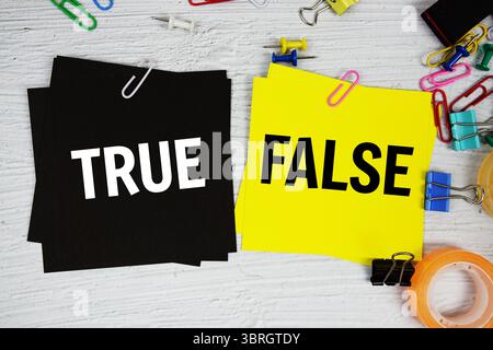 Richtig oder falsch Text auf Haftnotiz mit Briefpapier auf konkretem Hintergrund Stockfoto